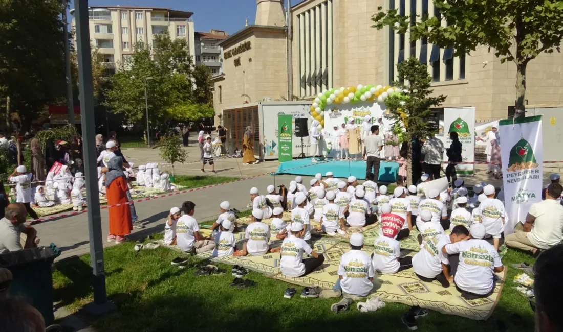 Etkinlikte çocuklar pankartlarla yürürken program tilavet, şiir, ilahi ve gösterilerle