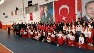 Kapalı spor salonundaki törende öğrencilerin şiir, halk oyunları, güreş ve